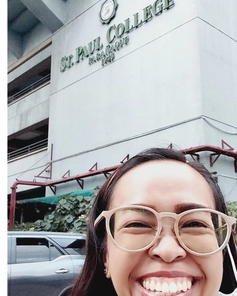 picture of a girl in front of a school building.