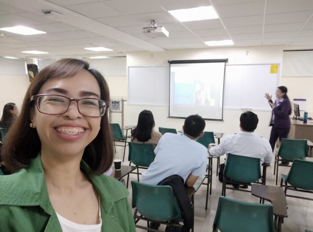 woman in front of people sitting in a conference room.